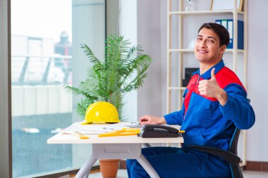 Foreman inşaat planına bakıyor.