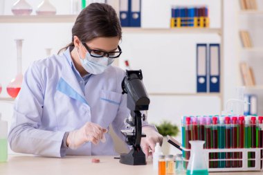 Laboratuar kimyageri güzellik ve makyaj ürünlerini kontrol ediyor.