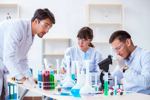 Equipe de químicos que trabalham no laboratório — Fotografia de Stock