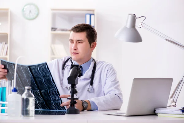 Männlicher Arzt schaut sich Laborergebnisse im Krankenhaus an — Stockfoto