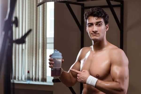 Homme avec des suppléments nutritifs dans la salle de sport — Photo