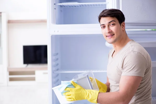 Homem de limpeza geladeira no conceito de higiene — Fotografia de Stock