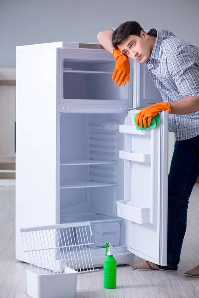 Muž úklid lednice v hygienické koncepci — Stock fotografie
