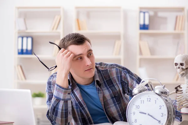 Student and skeleton preparing for school exams — Stock Photo, Image