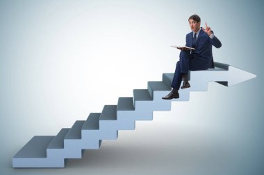 Kariyer merdiveni konsepti kitabı okuyan iş adamı