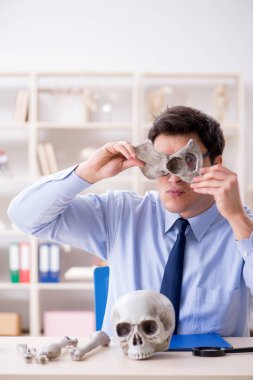 Komik çılgın profesör insan iskeletini inceliyor.