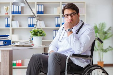 Hastanede çalışan tekerlekli sandalyedeki engelli doktor.