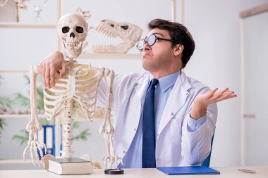 Çılgın profesör insan iskeleti üzerinde çalışıyor.