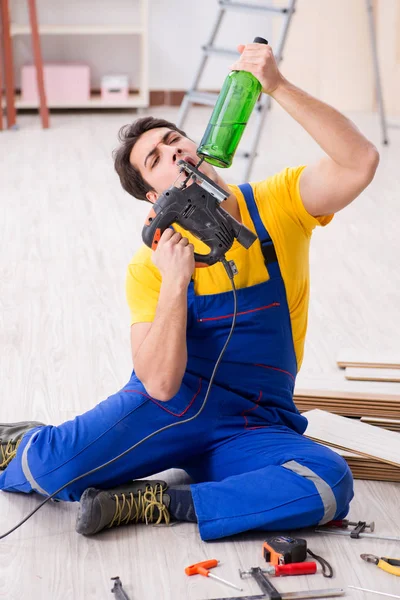 Fußbodenreparateur trinkt in der Pause Alkohol — Stockfoto