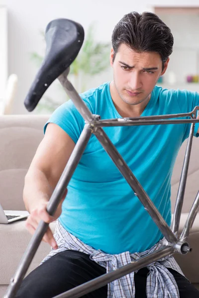 Joven reparando bicicleta en casa — Foto de Stock