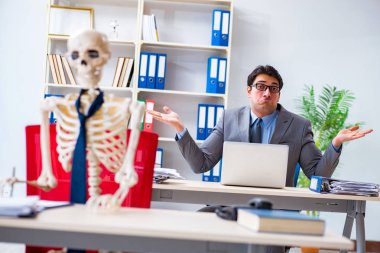 İskeletle çalışan bir iş adamı.