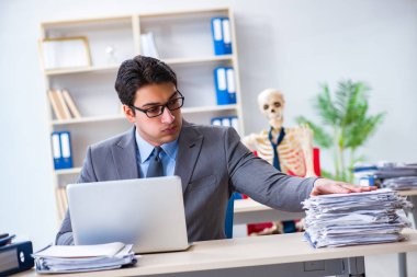 İskeletle çalışan bir iş adamı.