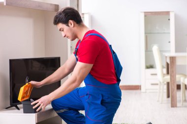 Profesyonel tamir mühendisi bozuk televizyonu tamir ediyor.