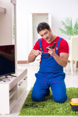 Profesyonel tamir mühendisi bozuk televizyonu tamir ediyor.