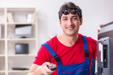 Profesyonel tamir mühendisi bozuk televizyonu tamir ediyor.