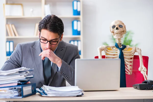 Businessman working with skeleton in office — Stock Photo, Image