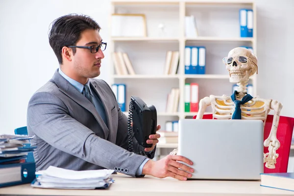 Empresario trabajando con el esqueleto en la oficina —  Fotos de Stock
