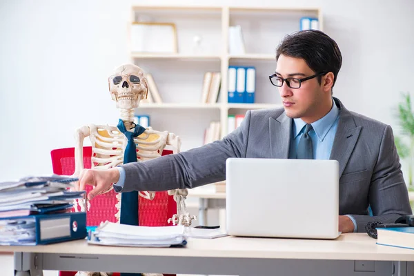 Businessman working with skeleton in office — Stock Photo, Image