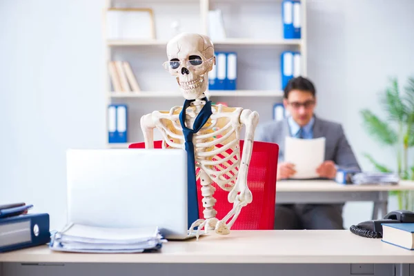 Homme d'affaires travaillant avec squelette dans le bureau — Photo