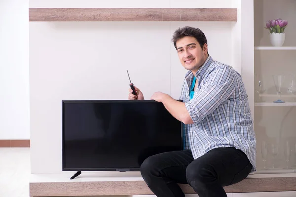 Muž opravy rozbité televize doma — Stock fotografie