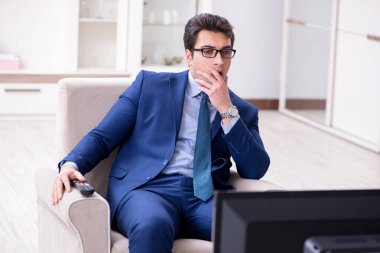 İş adamı ofiste televizyon izliyor.