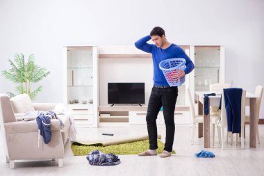 Genç adam çamaşırhane için kirli çamaşır topluyor.