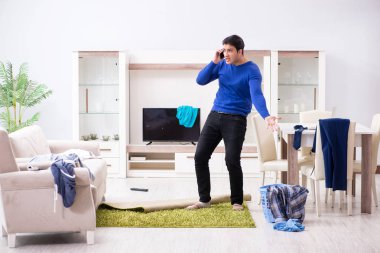 Genç adam çamaşırhane için kirli çamaşır topluyor.