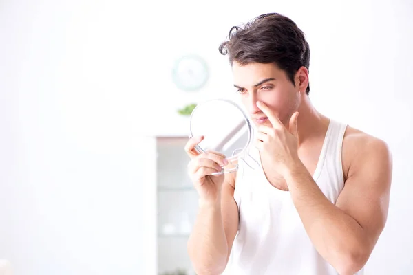 Young handsome man staring in the mirror — Stock Photo, Image