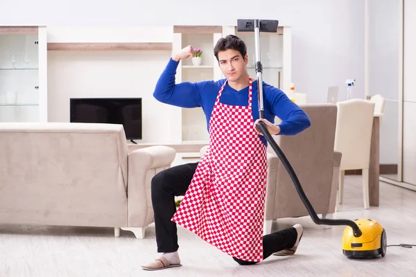 Young man vacuum cleaning his apartment — Stock Photo, Image