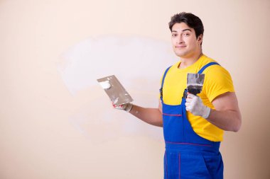 Duvara alçı yapıştıran genç müteahhit.