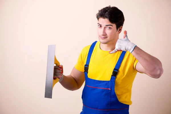 Empregado jovem empreiteiro aplicando gesso na parede — Fotografia de Stock