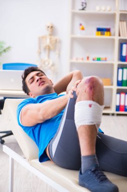 Spor sakatlığı geçiren hasta doktoru ziyaret ediyor.