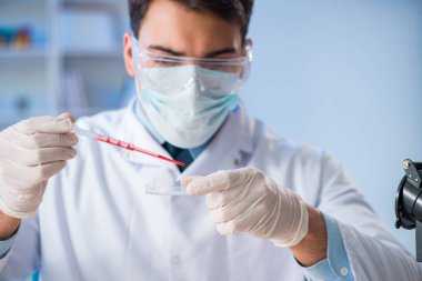 Laboratuvar asistanı hastanede kan örneklerini test ediyor.