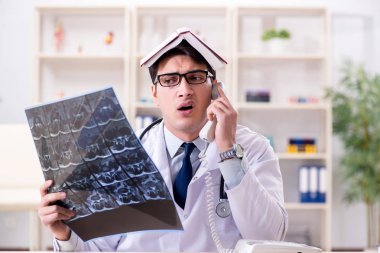 Genç doktor klinikteki röntgen görüntülerine bakıyor.