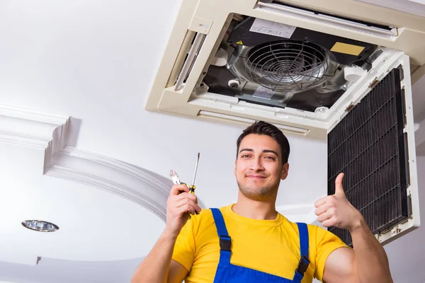 Repairman repairing ceiling air conditioning unit — Stock Photo, Image