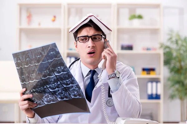 Genç doktor klinikteki röntgen görüntülerine bakıyor.