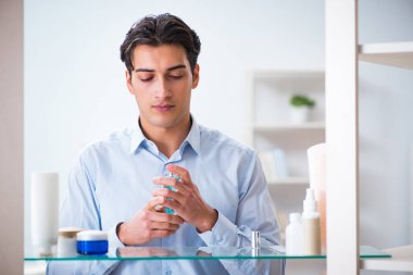 Adam banyoda çalışmak için giyiniyor.