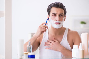 Genç yakışıklı adam sabah erkenden tıraş oluyor.