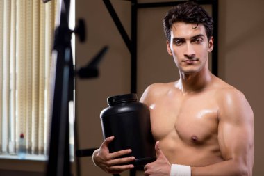 Spor salonunda besin takviyesi olan bir adam.