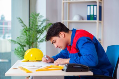 Foreman inşaat planına bakıyor.