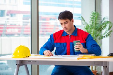 Foreman inşaat planına bakıyor.