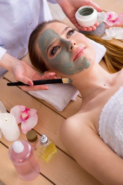 Yüz maskeli, spa sağlık konsepti olan genç bir kadın.