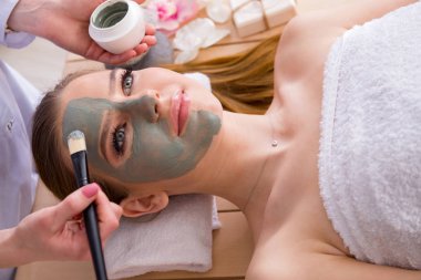 Yüz maskeli, spa sağlık konsepti olan genç bir kadın.