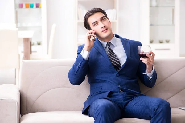 Businessman drinking wine sitting at home — Stock Photo, Image