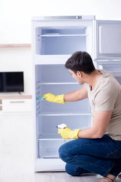 Man rengöring kylskåp i hygien koncept — Stockfoto