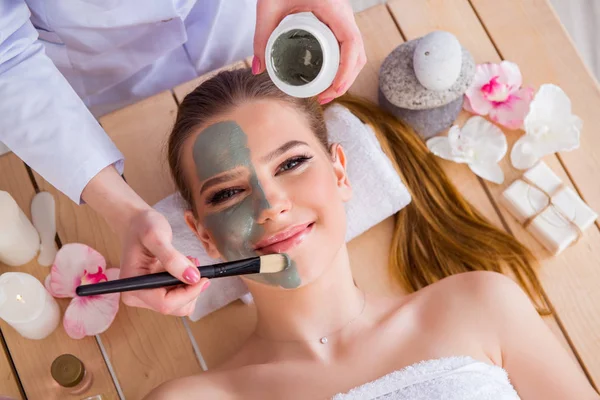 Ung kvinna i spa hälsa koncept med ansiktsmask — Stockfoto