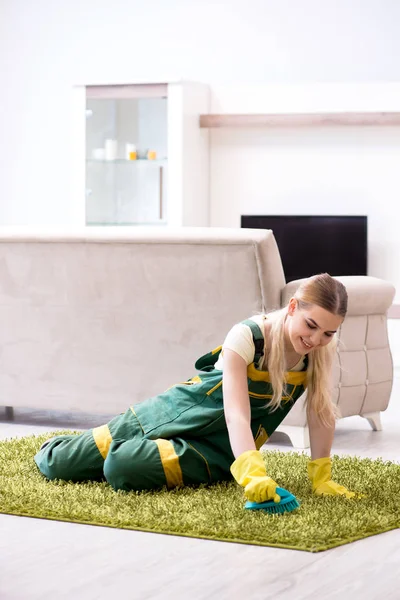 Professional female cleaner cleaning carpet