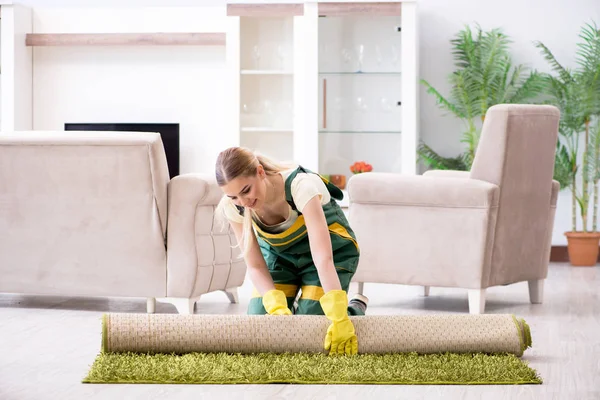 Professional female cleaner cleaning carpet