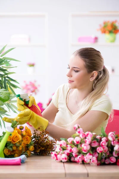 Mujer joven regando plantas en su jardín — Foto de Stock