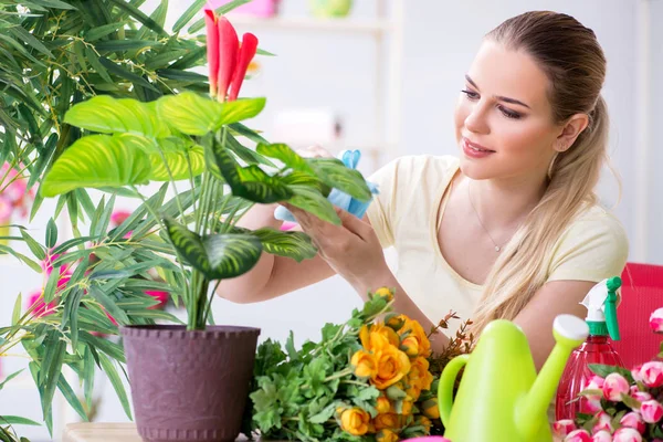 Mujer joven regando plantas en su jardín — Foto de Stock